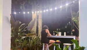a woman sitting at a table in a garden at Holiday Resort - SHA Plus in Ko Yao Noi