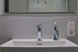 um lavatório de casa de banho com um dispensador de sabão em STERK Apartments - idyllisch - modern - stilvoll em Meckenbeuren