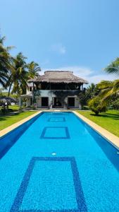 a swimming pool in front of a villa at Casa Maya private villa on the beach in Puerto Escondido