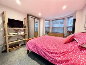 een slaapkamer met een bed, een tv en ramen bij Oliva Verde in Cromer