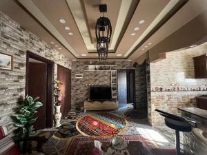 a large living room with a stone wall at Beida Bedouin House in Al Ḩayy