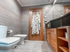 a bathroom with a white toilet and a wooden door at The Marbella Heights Boutique Hotel in Marbella