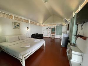 - une chambre avec un grand lit blanc dans l'établissement Holiday Resort - SHA Plus, à Ko Yao Noi