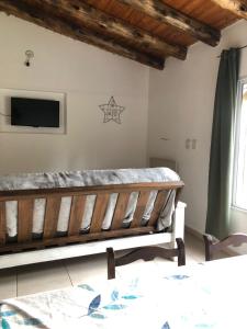 - une chambre avec un banc et une télévision murale dans l'établissement Cabañas Vista Andes, à Luján de Cuyo