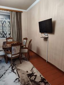 a room with a table and a television on a wall at Ideal in Akhaltsikhe