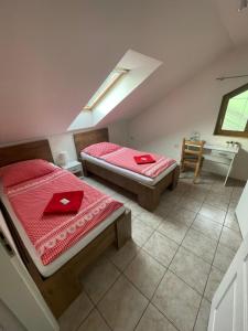 two beds in a room with a sink and a desk at Penzion pod lesem in Most