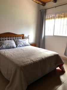 - une chambre avec un grand lit et une fenêtre dans l'établissement Cabañas Vista Andes, à Luján de Cuyo