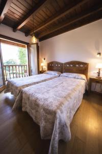 1 dormitorio con 2 camas y ventana grande en Camín de Mañanga, en Llanes