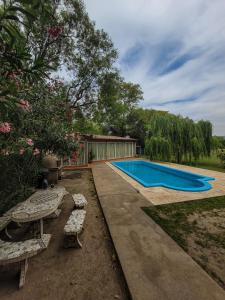 a swimming pool in a yard with two benches at Mamá Quilla in La Rioja
