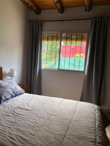 - une chambre avec un lit et une fenêtre dans l'établissement Cabañas Vista Andes, à Luján de Cuyo