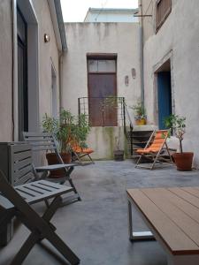 grupa krzeseł i stołów na patio w obiekcie L'appartement au cœur de Sète. w mieście Sète