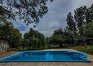 a blue swimming pool in a yard with trees at Mamá Quilla in La Rioja