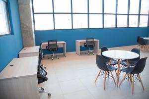 una oficina con mesa, sillas y una pared azul en Depa Arena y Fundidora, en Monterrey