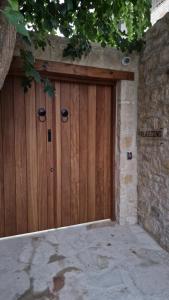 un par de puertas de madera en una pared de piedra en Palazzino Luxury Suites, en Lofou