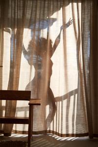 een schaduw van een vrouw die door een raam kijkt bij Barcarola Club in Puerto del Carmen