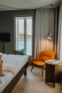 a bedroom with a bed and a chair and a window at Südspeicher in Kappeln