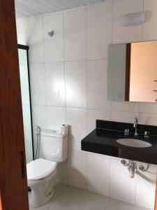 W łazience znajduje się toaleta, umywalka i lustro. w obiekcie Chalés Aguá Cristalina w mieście Visconde De Maua