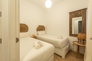 mały pokój z 2 łóżkami i lustrem w obiekcie Modern with balcony- 2Bd 2Bth- San Vicente w Sewilli