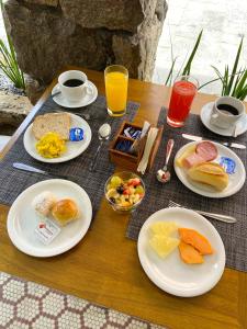 a table topped with plates of breakfast foods and drinks at Pousada Catedral in Petrópolis