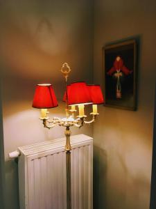 a lamp with two red lamps on a wall at Les Ambassadeurs in Spa