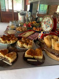 uma mesa cheia de diferentes tipos de pão e pastelaria em Chalés Aguá Cristalina em Visconde de Mauá