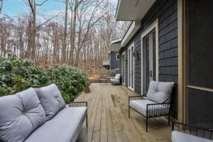 a porch with a couch and two chairs on a house at The Sanctuary at Deer Dune , Saugatuck in Saugatuck