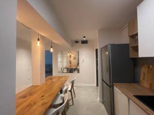 a kitchen with a wooden table and a refrigerator at Apartament Mony in Timişoara