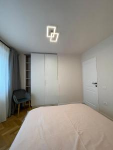 a bedroom with a bed and a light on the ceiling at Apartament Mony in Timişoara
