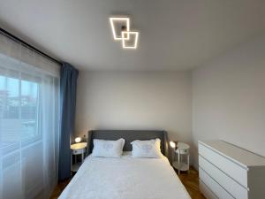 a bedroom with a bed with two pillows and a window at Apartament Mony in Timişoara