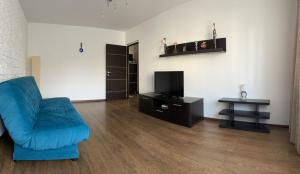 a living room with a blue couch and a television at Cozy Loft in Piteşti