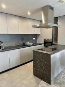 eine Küche mit weißen Schränken und einer schwarzen Arbeitsplatte in der Unterkunft Apartmány Residence in Donovaly