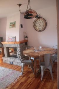 een eetkamer met een tafel en een klok aan de muur bij CHECK-IN CASAS Luana in Benasque