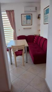 sala de estar con mesa y sofá rojo en Апартамент в Комплексе Сансет Кошарица,Солнечный берег, en Kosharitsa