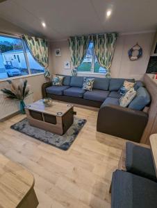 sala de estar con sofá azul y mesa en the fishing boat en Port Seton