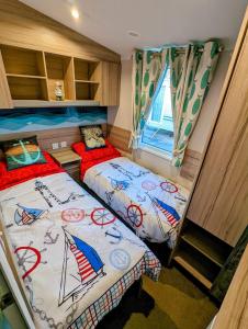 Habitación pequeña con 2 camas y ventana en the fishing boat en Port Seton