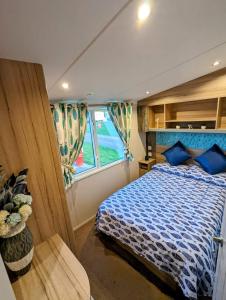 a bedroom of a boat with a bed and a window at the fishing boat in Port Seton