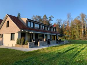 dom z dużym trawnikiem przed nim w obiekcie STERK Apartments - idyllisch - modern - stilvoll w mieście Meckenbeuren