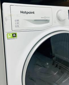a close up of a washing machine with a door at Beautiful and Homely 3 Bed House With FREE Parking So Close To Man City and City Centre in Manchester