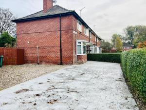 a brick house with a driveway in front of it at Beautiful and Homely 3 Bed House With FREE Parking So Close To Man City and City Centre in Manchester