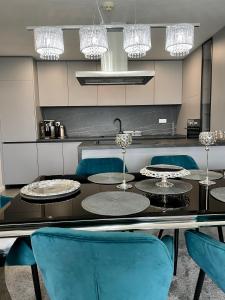 comedor con mesa negra y sillas azules en Apartmány Residence, en Donovaly