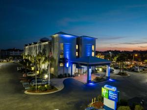 Holiday Inn Express North Myrtle Beach - Little River, an IHG Hotel في ليتل ريفر: مبنى كبير وامامه موقف سيارات
