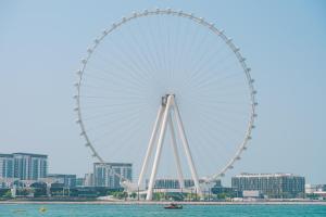 a large ferris wheel in front of a city at Sonder Business Bay in Dubai