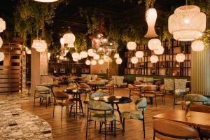 a restaurant with tables and chairs and chandeliers at Sonder Business Bay in Dubai