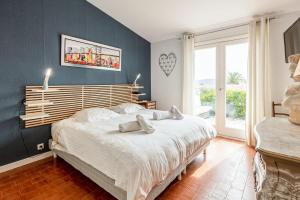 - une chambre avec un grand lit et un mur bleu dans l'établissement Villa des Rives - Welkeys, à Grimaud
