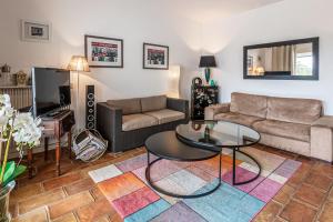 a living room with a couch and a table at Villa des Rives - Welkeys in Grimaud