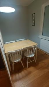 una mesa de comedor con 2 sillas blancas alrededor en Rauma City Apartments, en Rauma