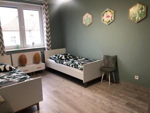 een slaapkamer met een bed, een stoel en een raam bij Apartament Mia in Malbork