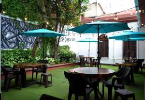 un patio con tavoli, sedie e ombrelloni di 4 Grados Hostal a Guatemala