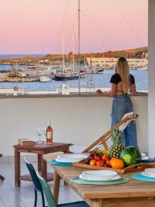 Una donna in piedi su un cornicione che guarda un porticciolo di Otranto perla d'Oriente a Otranto