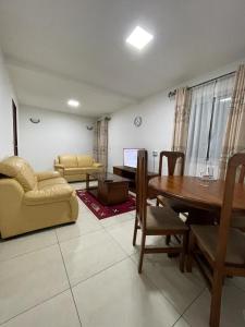 uma sala de estar com uma mesa e uma sala de jantar em Résidence 2JGE em Douala